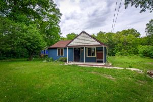 Front wide shot of the blue home at 6817 e jk ave in kalamazoo mi